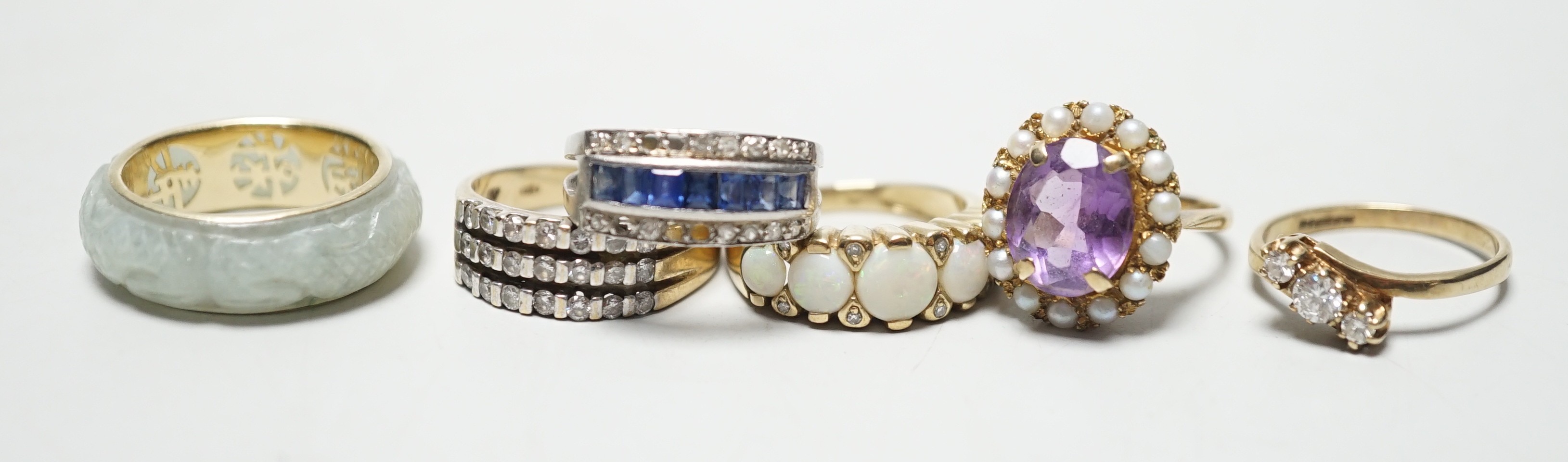 Four assorted modern 9ct god and gem set rings including amethyst and split pearl and white opal and diamond chip, gross 13.5 grams, together with a modern 585 and jade? ring, gross 4.7 grams and a white metal, sapphire